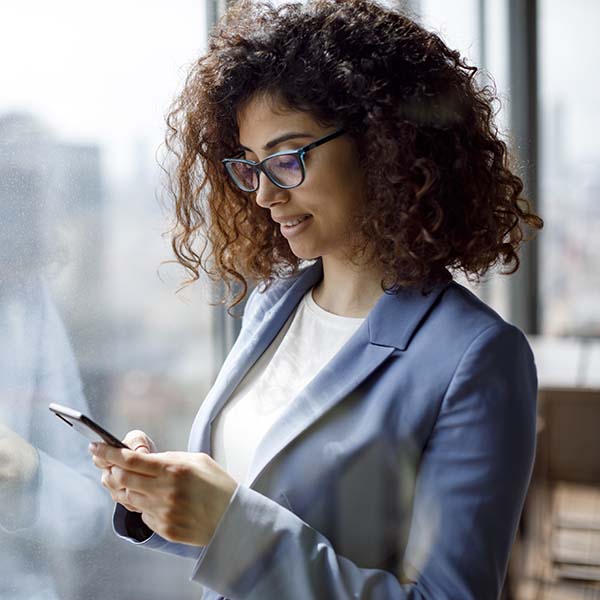 Young businesswoman using smart phone in office